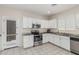 Well-equipped kitchen with white cabinetry, stainless steel appliances, and access to the backyard at 2559 N 73Rd Dr, Phoenix, AZ 85035