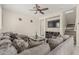 Cozy living room featuring a large sectional sofa, ceiling fan, and entertainment center with fireplace at 2559 N 73Rd Dr, Phoenix, AZ 85035