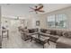 Spacious living room featuring tile flooring, a sectional sofa, and a ceiling fan with natural lighting at 2559 N 73Rd Dr, Phoenix, AZ 85035