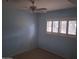 Bedroom featuring a ceiling fan, a window with white shutters, and light blue walls at 3031 N Civic Center Plz # 113, Scottsdale, AZ 85251