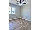 A cozy bedroom featuring wood-look tile floors, a ceiling fan, and a bright window at 3049 W Dahlia Dr, Phoenix, AZ 85029