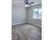 Empty bedroom with wood-look tile flooring, neutral walls, and a modern ceiling fan at 3049 W Dahlia Dr, Phoenix, AZ 85029