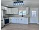 Bright, modern kitchen boasts white cabinets, quartz countertops, stainless steel appliances, and a view to the backyard at 3049 W Dahlia Dr, Phoenix, AZ 85029