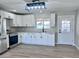 Bright, modern kitchen boasts white cabinets, quartz countertops, stainless steel appliances, and a view to the backyard at 3049 W Dahlia Dr, Phoenix, AZ 85029