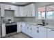 Beautifully renovated kitchen featuring stainless steel appliances, quartz countertops, and classic white cabinets and undermount sink at 3049 W Dahlia Dr, Phoenix, AZ 85029