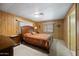 Bright primary bedroom featuring a large bed and wood-paneled walls at 3160 E Main St # 110, Mesa, AZ 85213