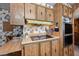 The vintage kitchen features wood cabinetry, black cooktop, and double ovens at 3160 E Main St # 110, Mesa, AZ 85213