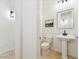 Bathroom with pedestal sink, wainscotting, and neutral color palette at 3221 E Lynx Pl, Chandler, AZ 85249