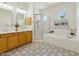 Bathroom featuring a double sink vanity, walk-in shower and soaking tub at 3221 E Lynx Pl, Chandler, AZ 85249