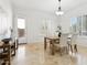 Bright dining room with a table set for four, featuring natural light and tiled floors at 3221 E Lynx Pl, Chandler, AZ 85249
