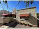 Inviting exterior view of this stucco home showing mature landscaping, a red awning and privacy wall at 3535 W Monte Cristo Ave # 129, Phoenix, AZ 85053