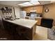 The kitchen features oak cabinets, a large island with breakfast bar and white appliances at 3535 W Monte Cristo Ave # 129, Phoenix, AZ 85053