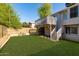 The backyard features a well-kept lawn, a raised wooden deck, and mature trees, perfect for relaxation at 3755 E Broadway Rd # 36, Mesa, AZ 85206