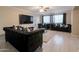 Spacious living room featuring a black sofa, a ceiling fan, and a modern entertainment center at 3755 E Broadway Rd # 36, Mesa, AZ 85206