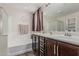Well-appointed bathroom featuring a soaking tub, double sinks, and dark wood cabinetry at 3915 S 186Th Ln, Goodyear, AZ 85338