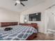Main bedroom with ceiling fan, en suite bathroom, and large television mounted on the wall at 3915 S 186Th Ln, Goodyear, AZ 85338