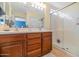 Bathroom featuring a wooden vanity, double sinks, and a spacious glass-enclosed shower, ensuring a luxurious experience at 3932 E Melinda Dr, Phoenix, AZ 85050