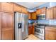 Modern kitchen boasts stainless steel refrigerator, oven, microwave, and warm-toned wooden cabinets at 3932 E Melinda Dr, Phoenix, AZ 85050