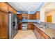 Well-equipped kitchen features stainless steel appliances, granite countertops, and warm wood cabinetry at 3932 E Melinda Dr, Phoenix, AZ 85050