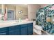 Colorful bathroom featuring a navy vanity and a unique dinosaur shower curtain at 4034 E Mine Shaft Rd, San Tan Valley, AZ 85143