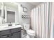 This bathroom boasts a modern vanity, a toilet with colorful striped shower curtain, and a 'Take a Seat' wall decor at 4034 E Mine Shaft Rd, San Tan Valley, AZ 85143