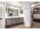 Bathroom featuring double sinks and a separate walk-in closet with storage at 4034 E Mine Shaft Rd, San Tan Valley, AZ 85143