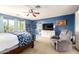 Bright main bedroom featuring blue walls, a ceiling fan, and a sitting area with an oversized recliner at 4034 E Mine Shaft Rd, San Tan Valley, AZ 85143