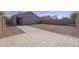 Large backyard featuring a paver patio, artificial turf, and desert landscaping at 41388 W Hopper Dr, Maricopa, AZ 85138