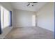 Spacious bedroom featuring a ceiling fan, neutral carpet and paint, and natural light from a window at 41388 W Hopper Dr, Maricopa, AZ 85138