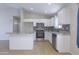 Modern kitchen with stainless steel appliances, white cabinets, tile backsplash, and tile floors at 41388 W Hopper Dr, Maricopa, AZ 85138