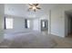 Bright living room with tile and carpet flooring, ceiling fan, and neutral paint at 41388 W Hopper Dr, Maricopa, AZ 85138