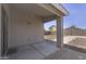 View of the covered patio with concrete flooring and access to the backyard at 41388 W Hopper Dr, Maricopa, AZ 85138