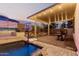 Inviting backyard featuring a covered patio with string lights and a built-in basketball hoop next to the pool at 4282 N 180Th Dr, Goodyear, AZ 85395