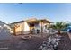 Spacious backyard with a covered patio, built-in grill, fire pit, desert landscaping, and access to the pool at 4282 N 180Th Dr, Goodyear, AZ 85395