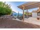 Large backyard featuring outdoor seating, desert landscaping, a pool, a covered patio, and a pergola at 4282 N 180Th Dr, Goodyear, AZ 85395