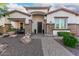 Inviting front exterior with a covered porch, stone accents, mature landscaping, and a paved walkway at 4282 N 180Th Dr, Goodyear, AZ 85395