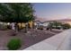 Charming single-story home featuring desert landscaping, stone accents, and inviting curb appeal at dusk at 4282 N 180Th Dr, Goodyear, AZ 85395