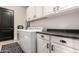 Well-equipped laundry room with white cabinets, modern appliances, and a sleek, dark countertop at 4282 N 180Th Dr, Goodyear, AZ 85395