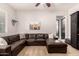 A cozy living room featuring a large leather sectional sofa and ceiling fan at 4282 N 180Th Dr, Goodyear, AZ 85395