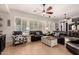 Bright living room featuring large windows, two ceiling fans and comfortable seating for relaxing or entertaining at 4282 N 180Th Dr, Goodyear, AZ 85395