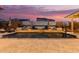 Beautiful backyard pool with water feature, basketball hoop, lounge chairs, and freshly laid travertine at 4282 N 180Th Dr, Goodyear, AZ 85395
