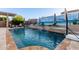 Backyard pool featuring a waterfall feature, lounge chairs, and a mural on the privacy wall at 4282 N 180Th Dr, Goodyear, AZ 85395