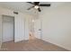Bedroom with ceiling fan offers ample closet space and access to a bathroom, providing convenience and comfort at 4317 W Orangewood Ave, Glendale, AZ 85301