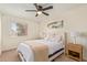 Bright bedroom features a ceiling fan, nightstands with lamps, and a queen bed with cozy bedding at 4317 W Orangewood Ave, Glendale, AZ 85301