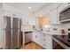 Well-lit kitchen with modern white cabinets, stainless steel appliances, and updated fixtures at 4317 W Orangewood Ave, Glendale, AZ 85301