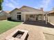 A private backyard features a covered patio, a fire pit, and manicured lawn for entertaining at 4626 E Villa Rita Dr, Phoenix, AZ 85032