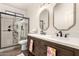 Beautiful bathroom with a glass shower, dark wood cabinet, double sinks, and stylish gold framed mirrors at 4706 E Des Moines St, Mesa, AZ 85205