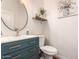 Stylish powder bathroom with modern vanity, round mirror, and decorative shelf with ornamental plants at 4706 E Des Moines St, Mesa, AZ 85205