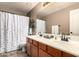 Bathroom features a white sink and shower, a wooden cabinet, and white towels and decorations at 4706 E Des Moines St, Mesa, AZ 85205