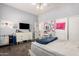 Bedroom featuring wood flooring, playful decor, dresser with mounted TV and door access to the bathroom at 4706 E Des Moines St, Mesa, AZ 85205